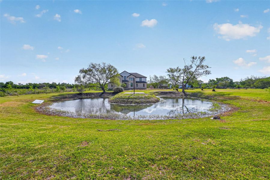 Pond view with open grassy surroundings and peaceful rural setting.