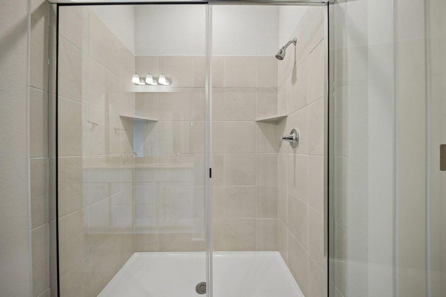 A well-appointed shower space boasts contemporary tilework and convenient built-in shelving. A well-appointed shower space boasts contemporary tilework and convenient built-in shelving.