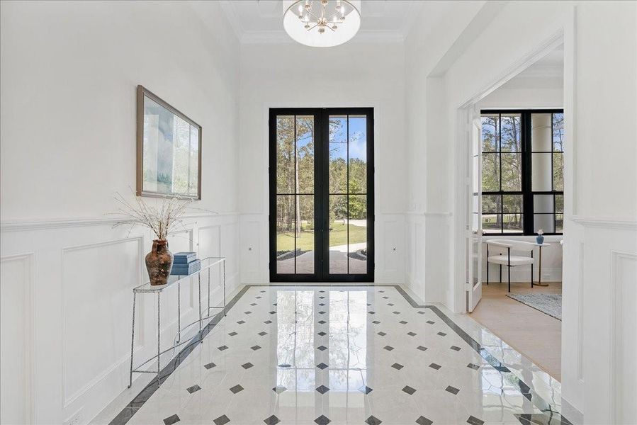 A commanding estate arrival begins with steel-and-glass French doors, four glowing gas lanterns, and custom masonry that immediately signals this home was built to a different standard.