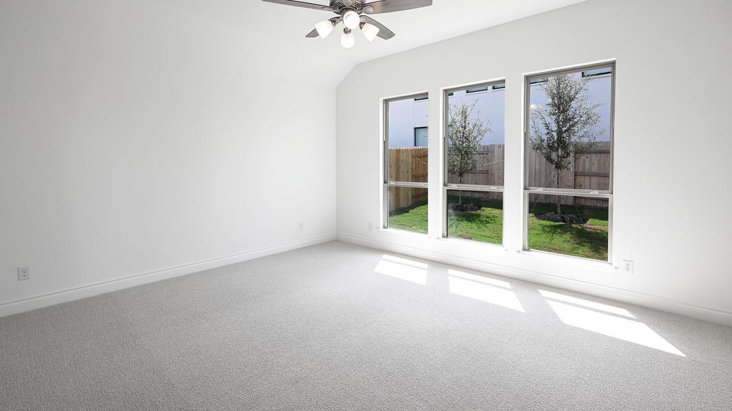 Carpeted empty room featuring ceiling fan and vaulted ceiling Carpeted empty room featuring ceiling fan and vaulted ceiling
