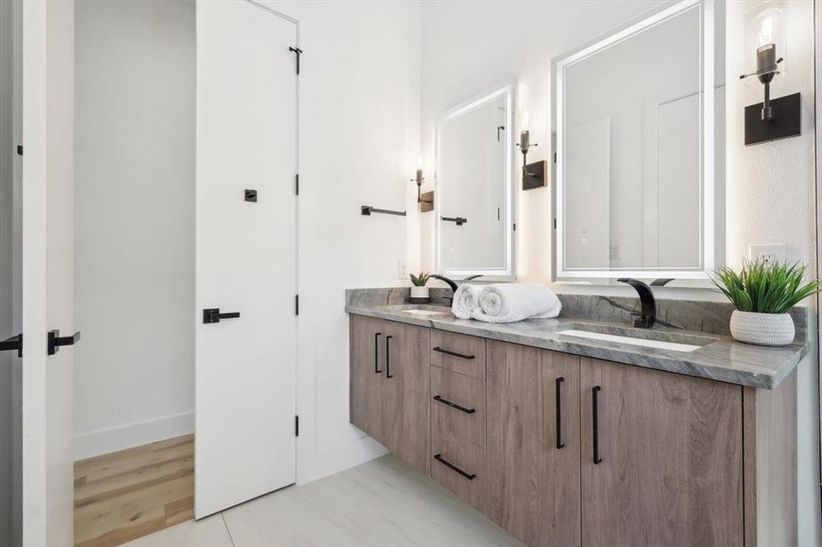 Bathroom with dual vanity and hardwood / wood-style flooring