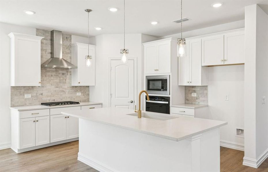 Spacious kitchen with recessed and pendant lighting
