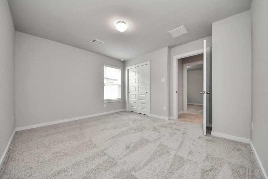 Secondary bath features tile flooring, bath/shower combo with tile surround, light stained wood cabinets, beautiful light countertop. Sample photo of completed home with similar floor plan. Actual colors and selections may vary.