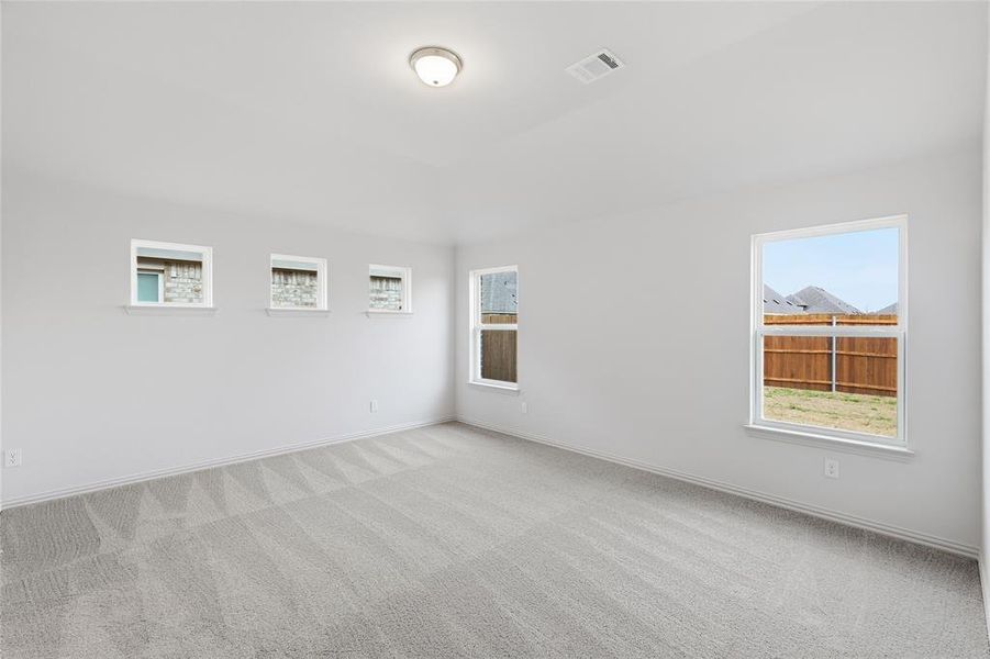 Empty room with light colored carpet and healthy amount of natural light