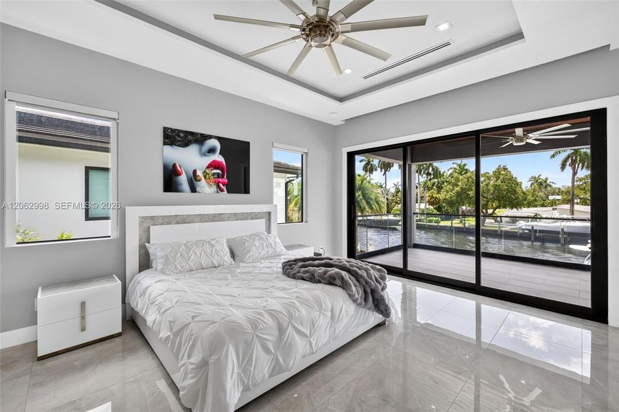 Primary bedroom suite w/ french doors, morning bar, en suite walk in closet and spa bathroom. Sliders lead to private balcony looking down the river
