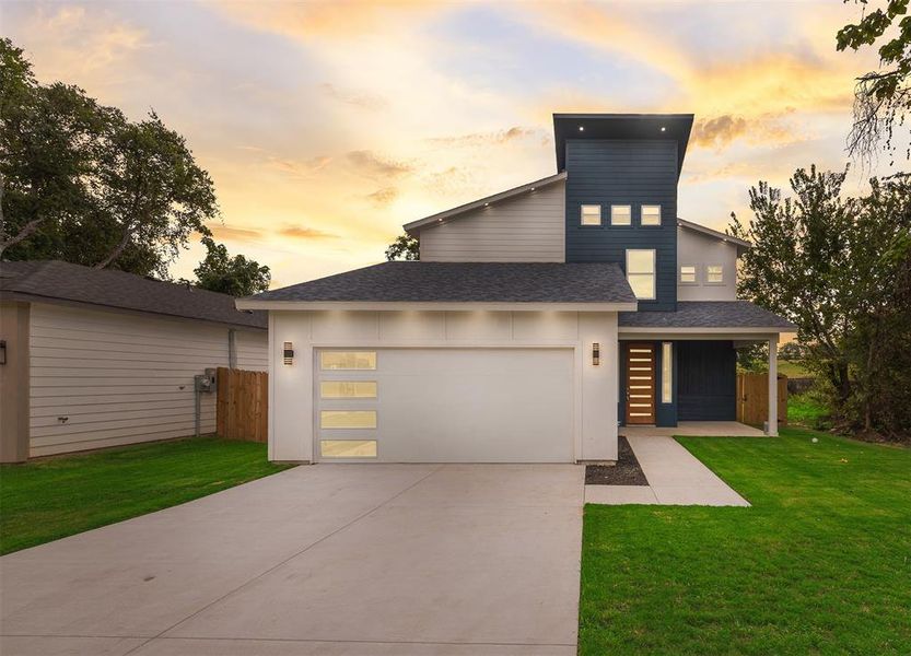 Modern home with roof with shingles, concrete driveway, and an attached garage Modern home with roof with shingles, concrete driveway, and an attached garage