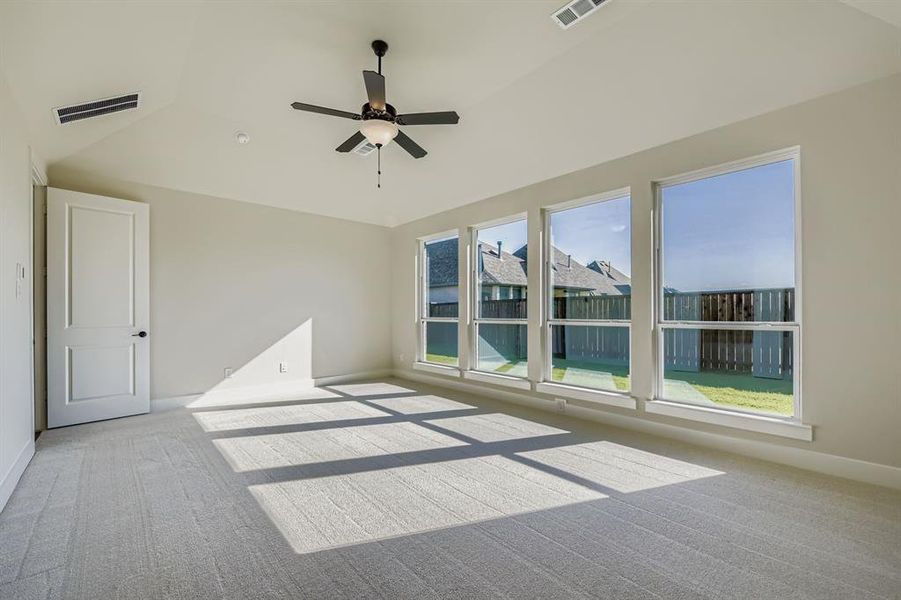 Spare room featuring carpet floors, a ceiling fan, and vaulted ceiling Spare room featuring carpet floors, a ceiling fan, and vaulted ceiling