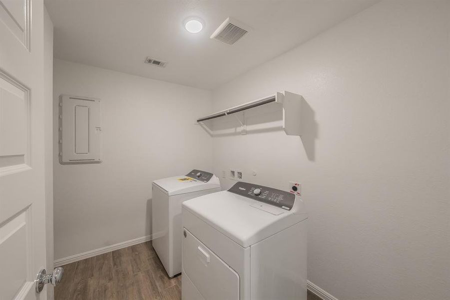 Washroom with dark wood-style floors, separate washer and dryer, and electric panel Washroom with dark wood-style floors, separate washer and dryer, and electric panel