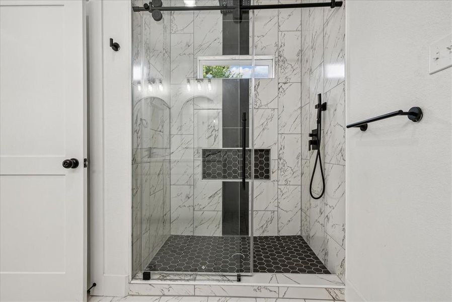 Primary bathroom featuring tile patterned flooring and a stand up shower with door