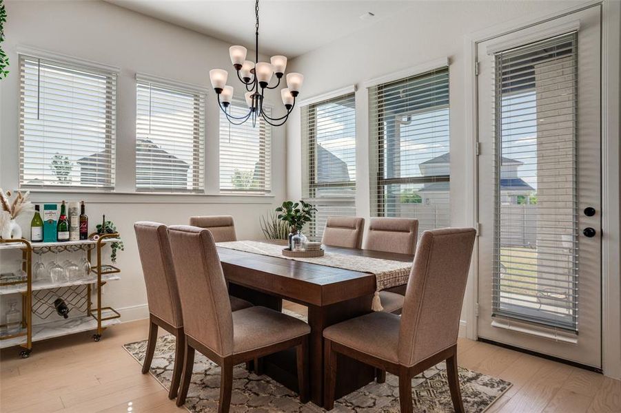 Dining area featuring hanging lights, light wood finished floors, and healthy amount of natural light