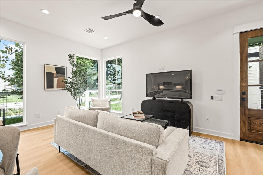 Main living volume — open plan, ceiling fan, natural light drawn through floor-to-ceiling glazing Main living volume — open plan, ceiling fan, natural light drawn through floor-to-ceiling glazing