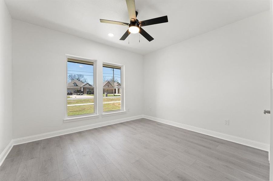 Empty room featuring ceiling fan and light wood finished floors