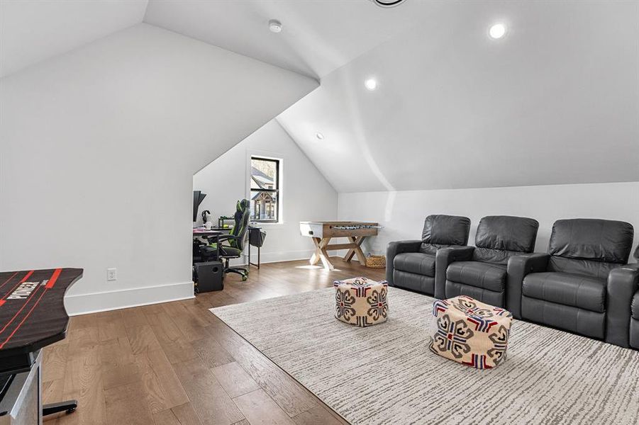 Living room featuring wood finished floors, vaulted ceiling, baseboards, and recessed lighting Living room featuring wood finished floors, vaulted ceiling, baseboards, and recessed lighting