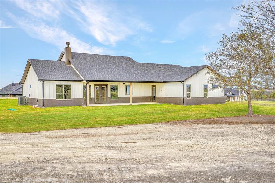 View of front of property with cooling unit, a front yard, and french doors