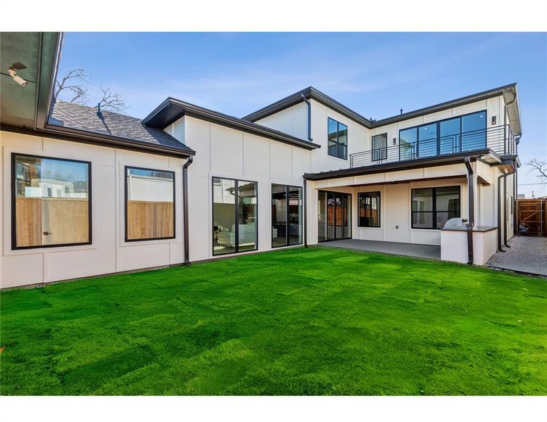 Rear view of house featuring a patio and a yard