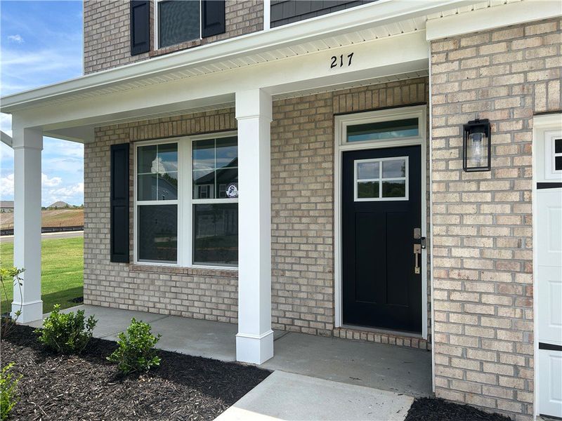 A welcoming brick exterior boasts a covered porch,