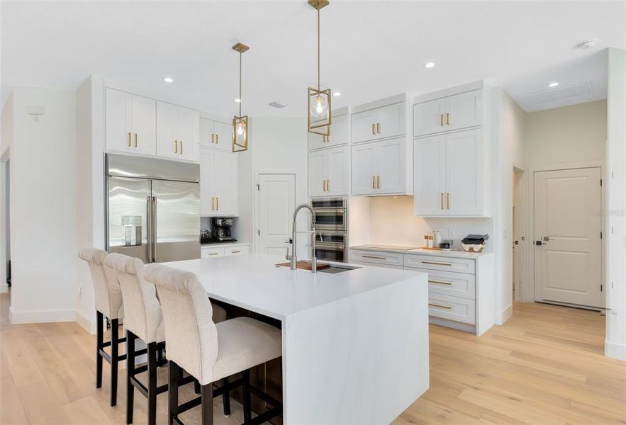 The chef’s kitchen is a showstopper, featuring a stunning waterfall quartz-topped breakfast bar.