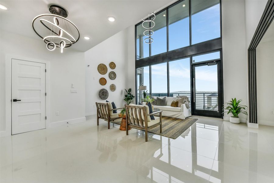 The bay becomes living artwork in the great room. A two-story wall of glass pulls the water and sky inside, creating a dramatic setting for everyday living and memorable entertaining. The bay becomes living artwork in the great room. A two-story wall of glass pulls the water and sky inside, creating a dramatic setting for everyday living and memorable entertaining.