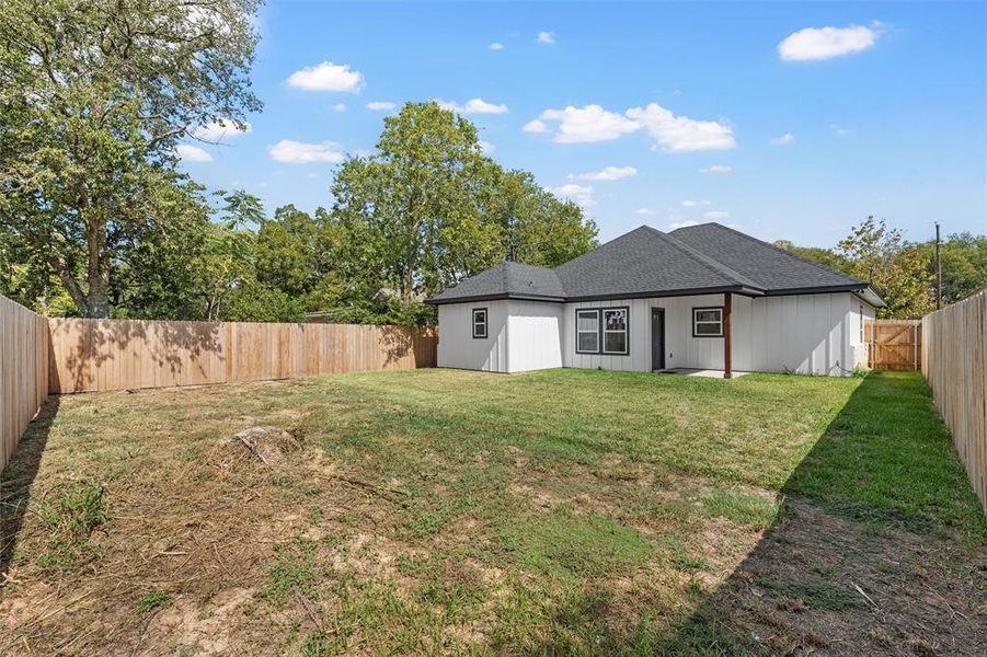 Back of property featuring a patio, a shingled roof, and a fenced backyard