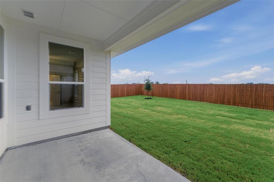 Expansive backyard featuring a manicured lawn and a privacy fence Expansive backyard featuring a manicured lawn and a privacy fence