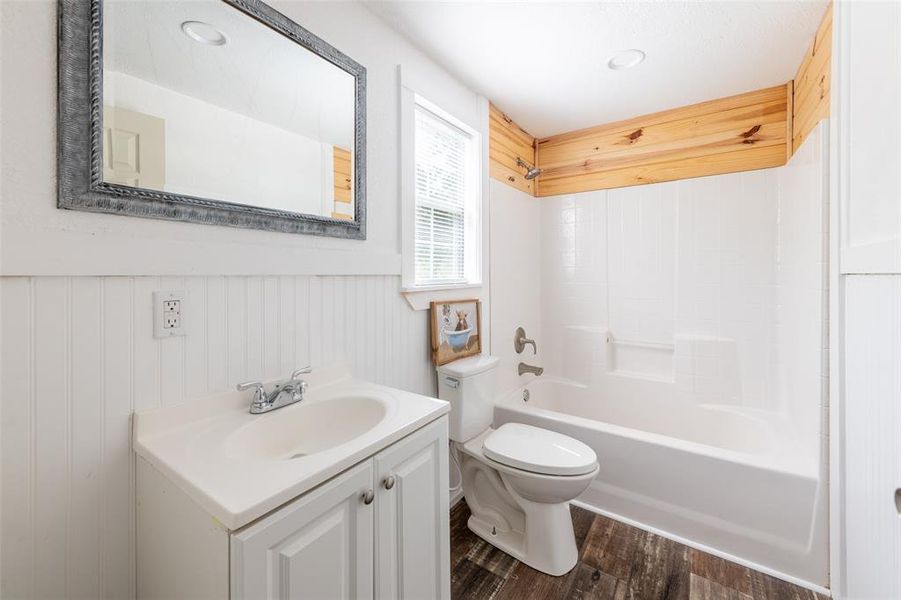 Bathroom featuring a white vanity with integrated sink, chrome faucet, and a large wall-mounted mirror