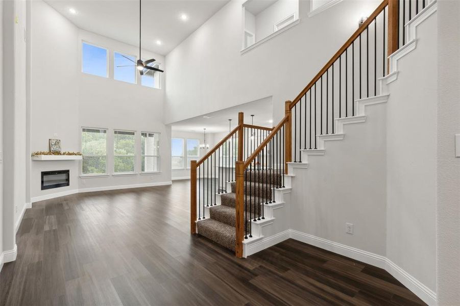 Stairway featuring ceiling fan, hardwood / wood-style flooring, and a high ceiling