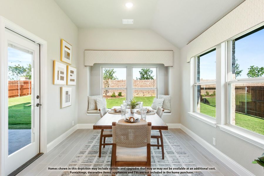 Bright dining area with vaulted ceiling, window bench seat, and backyard views through large windows Bright dining area with vaulted ceiling, window bench seat, and backyard views through large windows