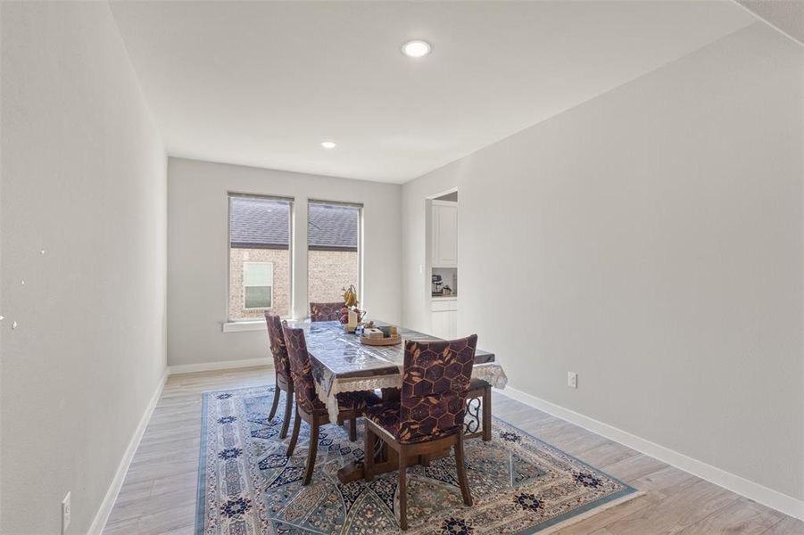 Dining room with light wood-style flooring and recessed lighting Dining room with light wood-style flooring and recessed lighting