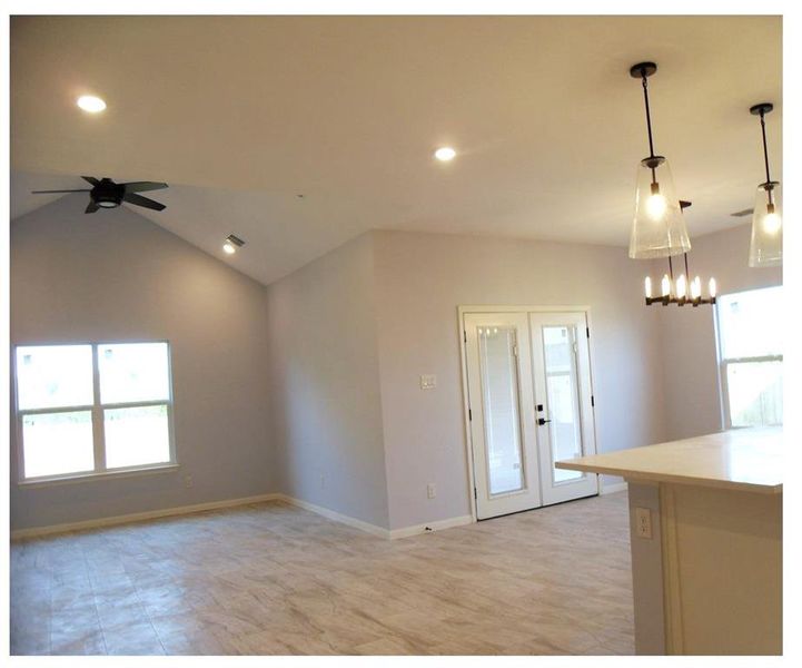 Kitchen featuring french doors, ceiling fan, vaulted ceiling, and pendant lighting