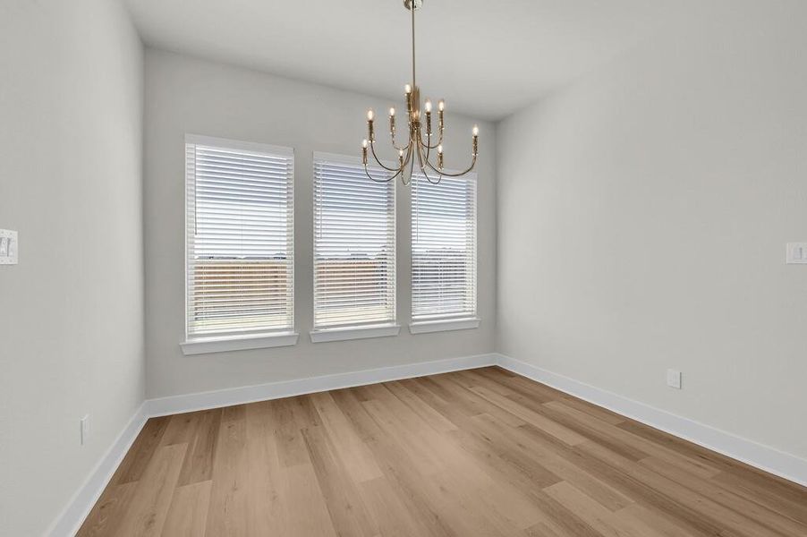 Unfurnished dining area featuring light wood-type flooring and a chandelier