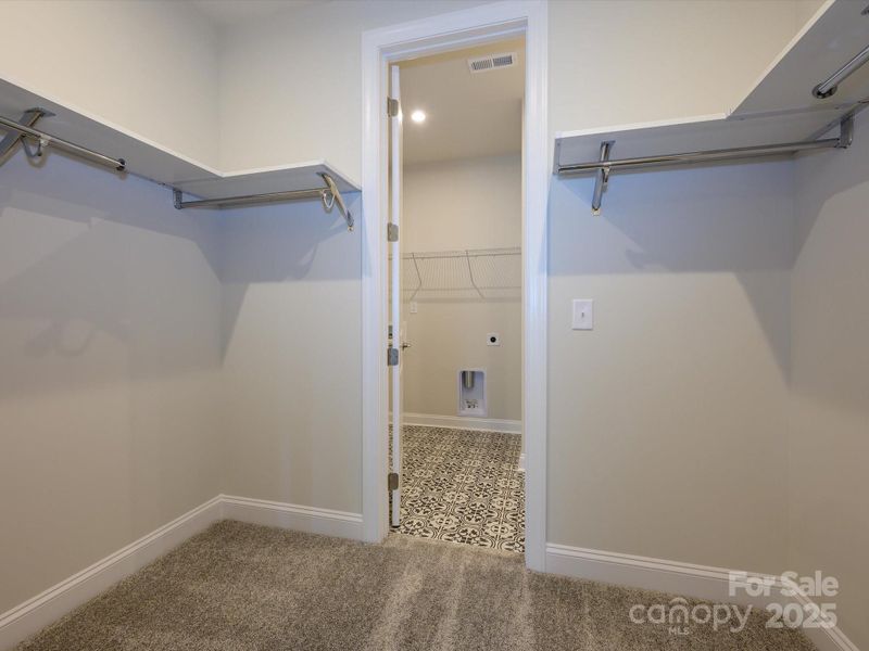 Primary Walk-In Closet Leading to Stylish Laundry Room