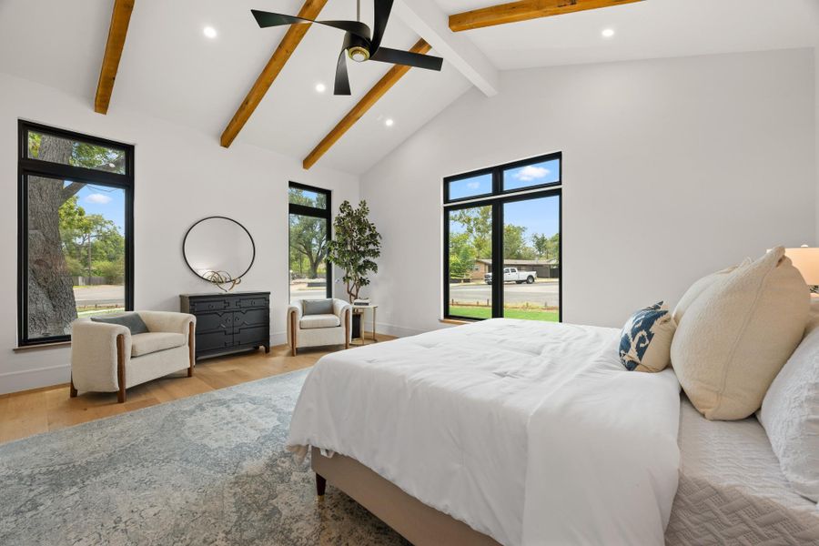 Soaring vaulted ceilings with exposed wood beams define this serene bedroom space.