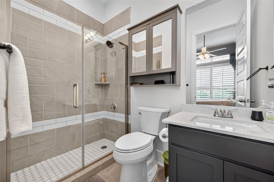 This modern bathroom features a sleek design with a glass-enclosed shower, beige tile walls, and a white and gray color scheme. It includes a vanity with a large mirror cabinet, a contemporary sink, and ample natural light from the adjacent room. This modern bathroom features a sleek design with a glass-enclosed shower, beige tile walls, and a white and gray color scheme. It includes a vanity with a large mirror cabinet, a contemporary sink, and ample natural light from the adjacent room.