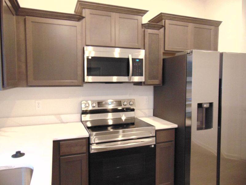 This is a sleek and modern kitchen to cook your family meals has stainless steel appliances and staggered cabinetry, as well as dreamy crowns