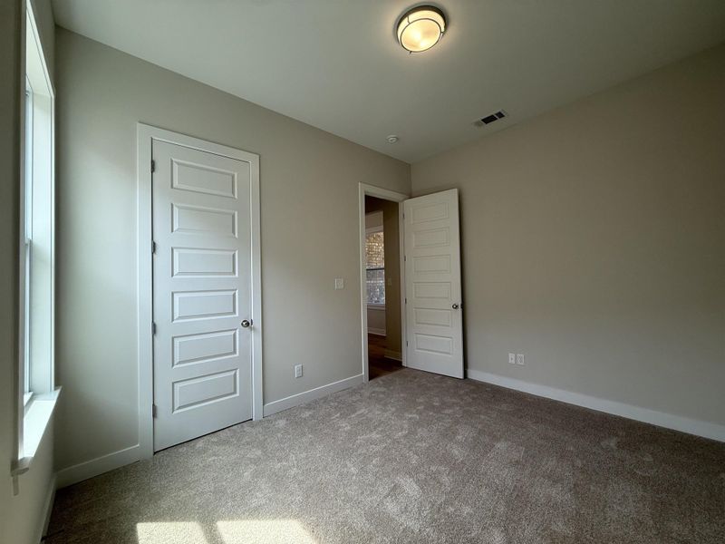 Unfurnished bedroom with carpet flooring and baseboards
