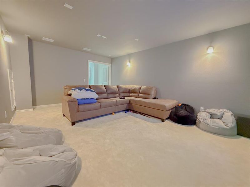 Living area featuring light carpet and baseboards