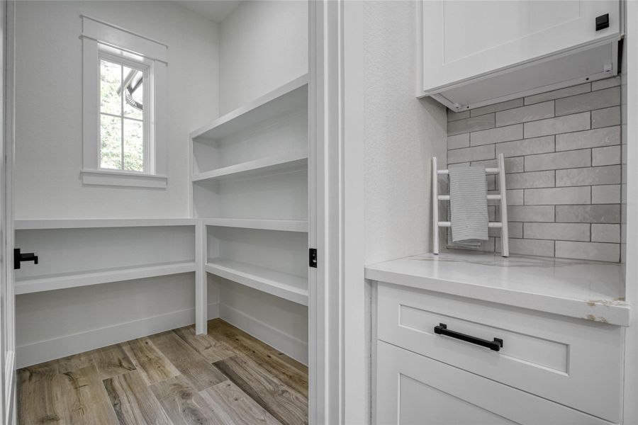 Large walk in pantry with lots of shelves for storage with a small butler's pantry at the entrance. Large walk in pantry with lots of shelves for storage with a small butler's pantry at the entrance.