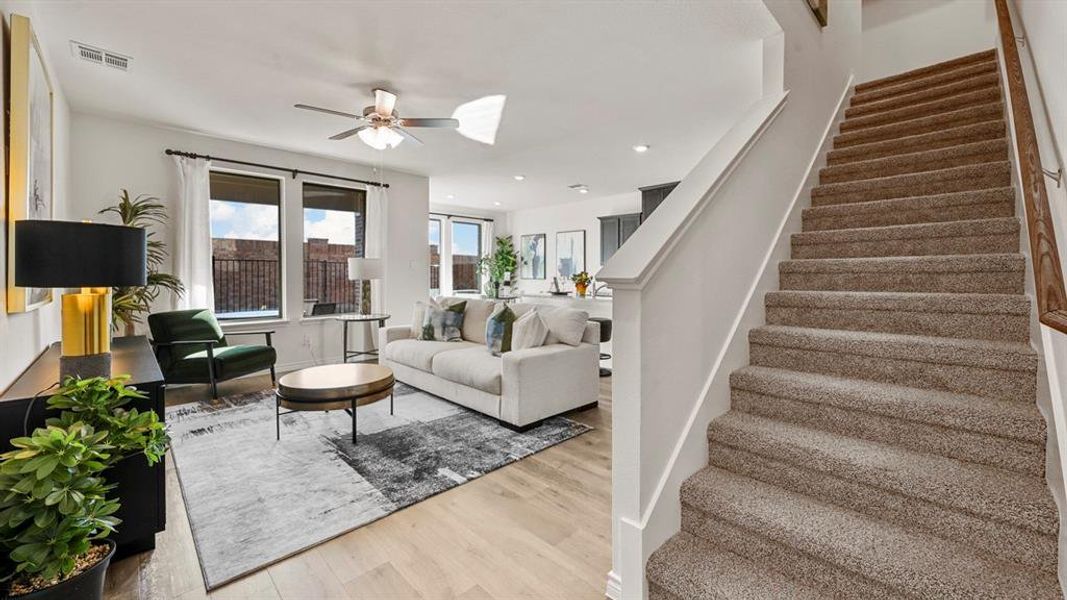 Living room with stairway, light wood finished floors, a ceiling fan, and recessed lighting