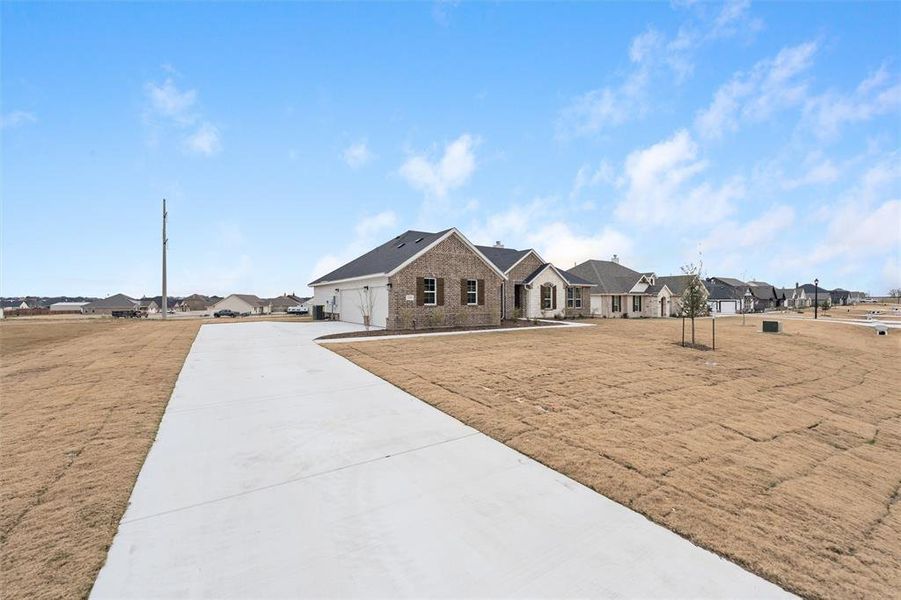 View of front of property featuring a garage, a residential view, and concrete driveway View of front of property featuring a garage, a residential view, and concrete driveway