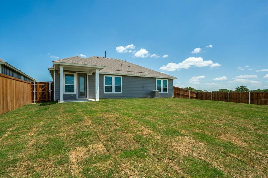 Back of house featuring a shingled roof and a fenced backyard Back of house featuring a shingled roof and a fenced backyard