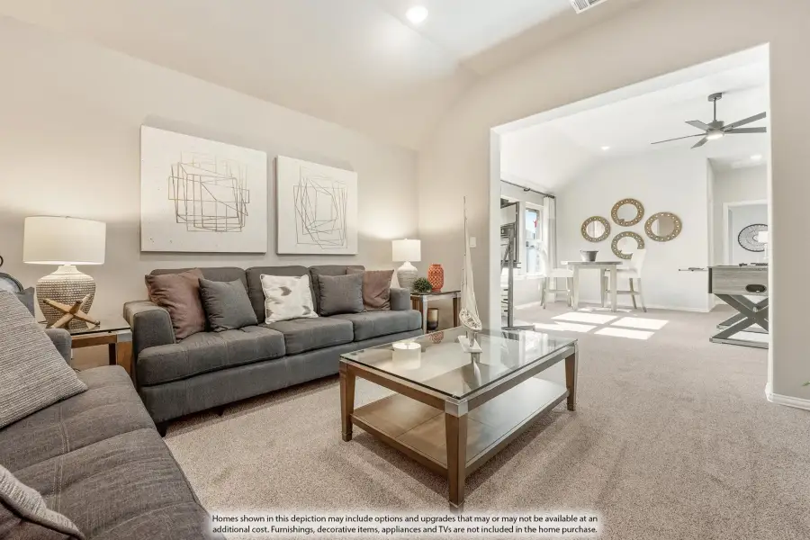 Living room with gray sofa, glass coffee table, vaulted ceiling, and open view into dining and game room areas. Living room with gray sofa, glass coffee table, vaulted ceiling, and open view into dining and game room areas.
