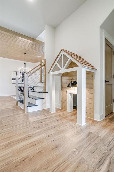 Unfurnished living room featuring light wood-style floors and a chandelier