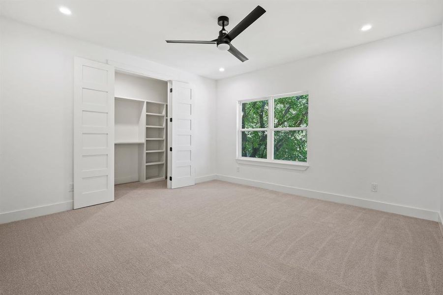 Unfurnished bedroom featuring ceiling fan, a closet, and light carpet