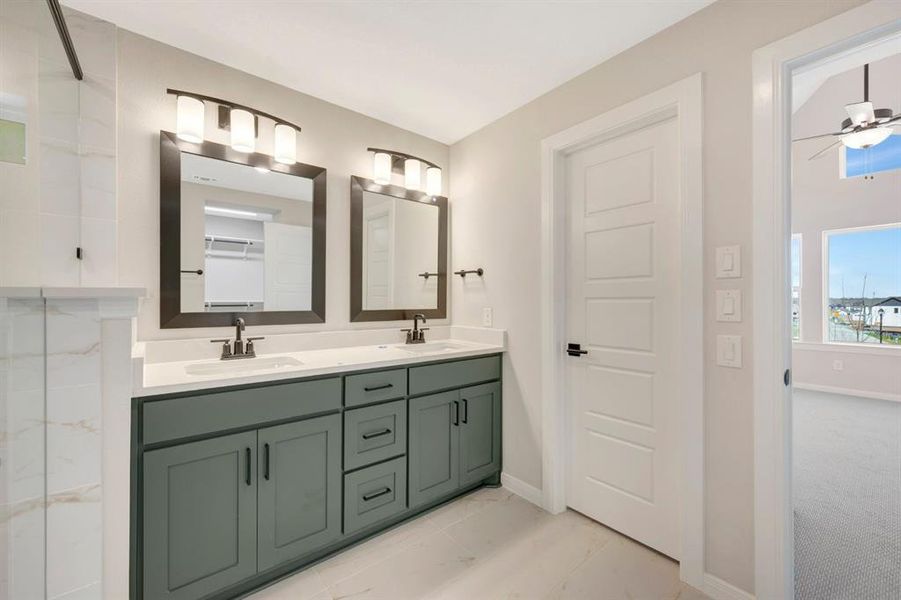 Bathroom featuring double vanity, ceiling fan, and light marble finish flooring