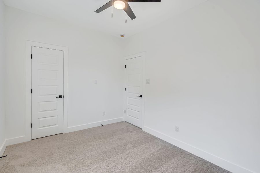 Alternate view of the secondary upstairs bedroom highlighting the spacious layout and access to the closet.