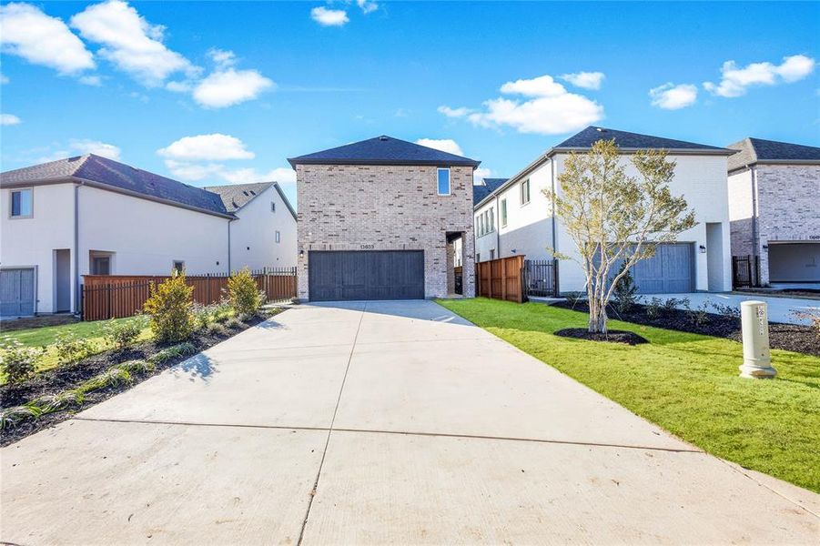 View of front of property with a garage and a front lawn