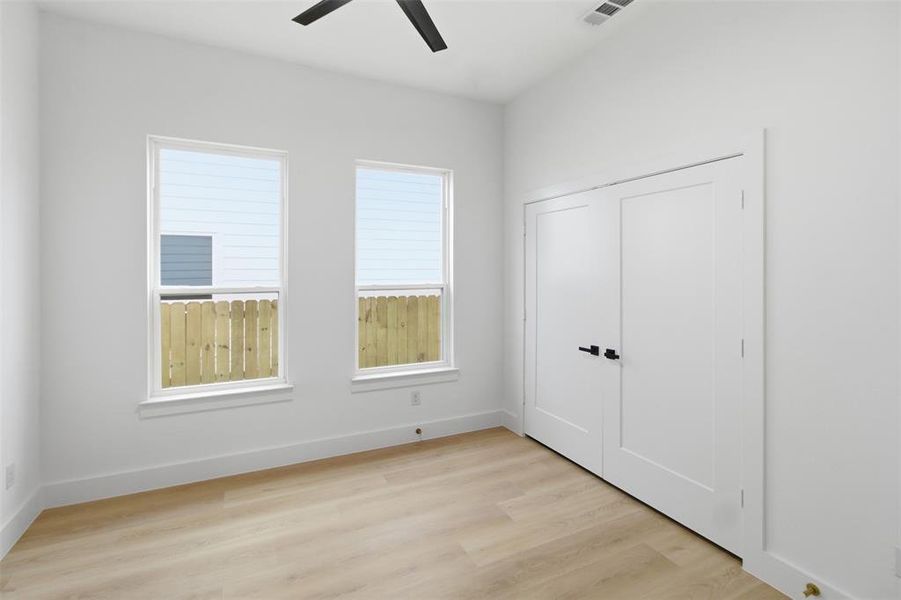 Unfurnished bedroom featuring light wood-type flooring, ceiling fan, and a closet