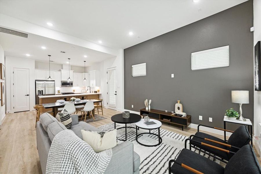 Alternate view of the first-floor living areas, featuring 11-foot ceilings and abundant natural light. The expansive layout offers a versatile design, accommodating any furniture configuration to create a flowing, breathable environment perfect for entertaining.