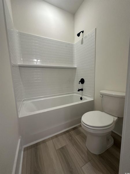 Bathroom featuring light wood-style floors and bathing tub / shower combination