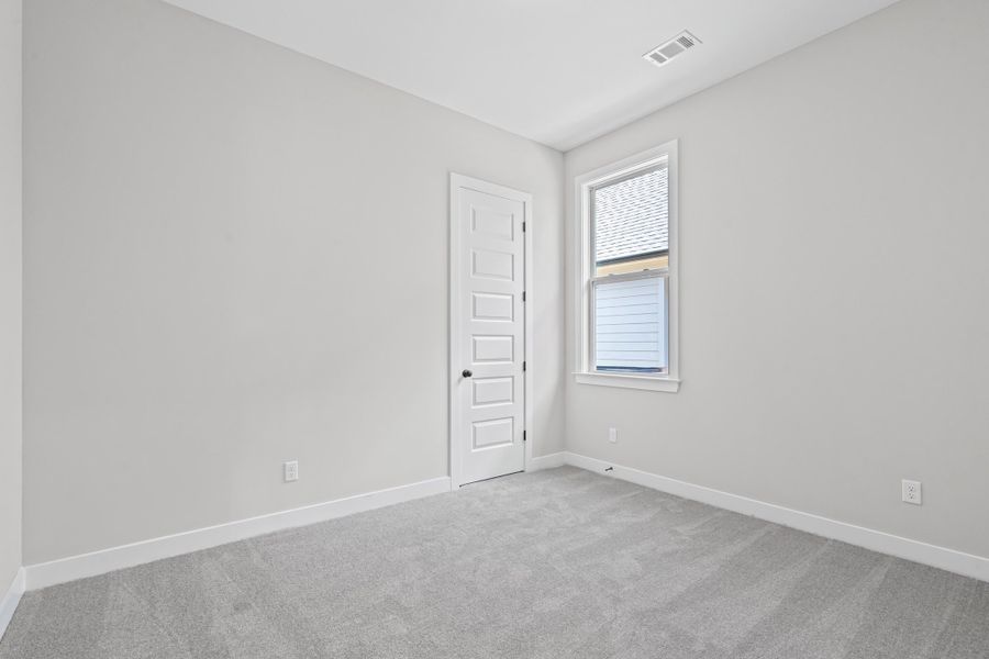 Spare room featuring light colored carpet and baseboards Spare room featuring light colored carpet and baseboards